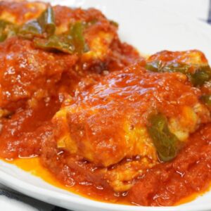 Plato de bacalao con tomate acompañado de pimientos verdes