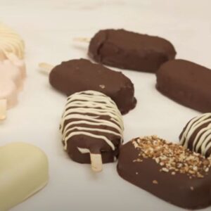 Helados de diferentes sabores y formas distribuidos sobre una mesa blanca