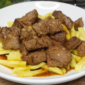 Plato de ternera al ajillo con patatas fritas