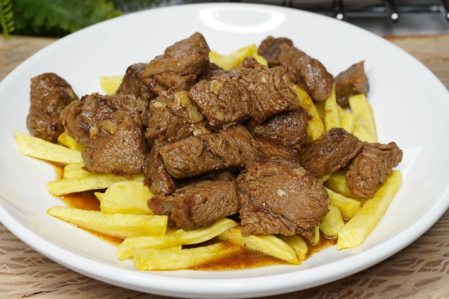 Plato de ternera al ajillo con patatas fritas